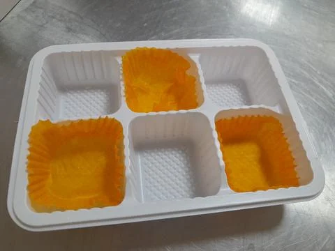 Plastic tray with three empty paper cupcake liners Stock Photos
