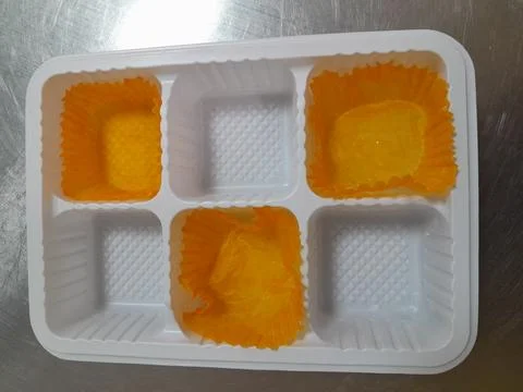 Plastic tray with three empty paper cupcake liners Stock Photos