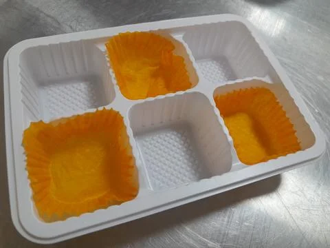 Plastic tray with three empty paper cupcake liners Stock Photos