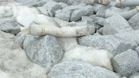 Plastic tubes and rocks on a melting snow Stock Footage 194839800