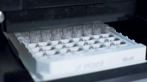 Plastic tubes on a tray filled with fluid while laboratory equipment works. Stock Footage 105675294