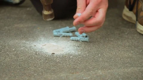 Plastic wall plug anchor inserting into drilled concrete hole close up with dust Stock Footage 334041280