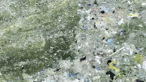 Plastic waste and microplastic debris polluting ocean water surface Video stock 333696555