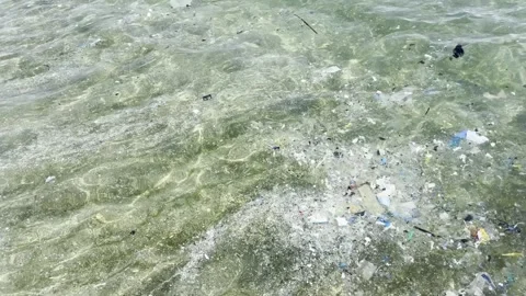 Plastic waste and microplastic debris polluting ocean water surface Video stock 333696828