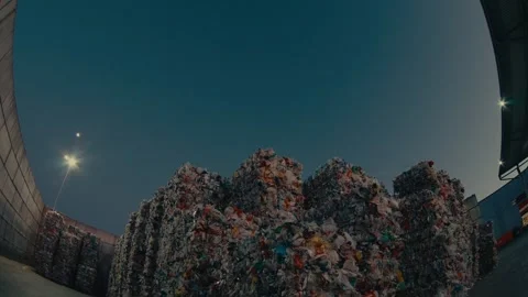 Plastic Waste Bales Stacked High at a Recycling Facility Under Night Sky Stock Footage 331166588