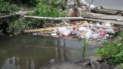 Plastic waste clogs a roadside drain. Stock Footage 323049089
