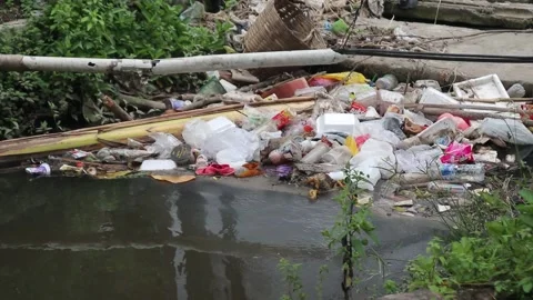 Plastic waste clogs a roadside drain. Stock Footage 323049090