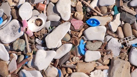 Plastic waste covers and garbage on pebble seashore after storm, closeup view. Stock Footage 116192320