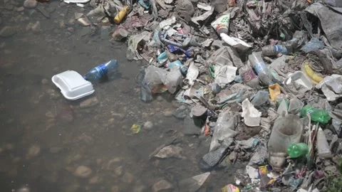 Plastic waste drifting down a polluted river in Port au Prince, Haiti Stock Footage 248431379