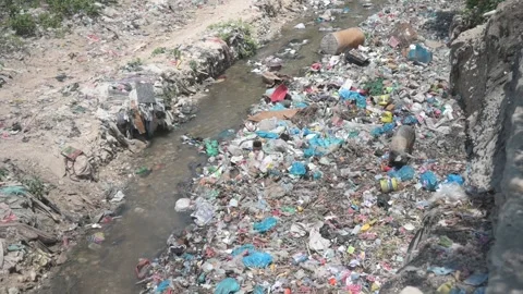 Plastic waste drifting down a polluted river in Port au Prince, Haiti Stock Footage 248441213