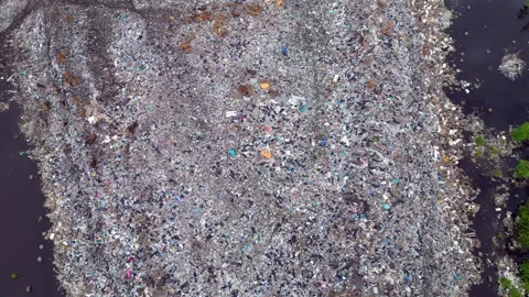Plastic waste polluting environment dump with cows. Spectacular aerial view Stock Footage 332617144
