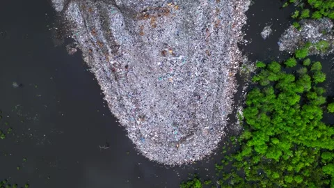 Plastic waste polluting environment dump with cows. Fantastic aerial view drone 動画素材 332617246
