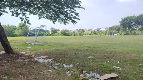 Plastic waste is strewn across an empty football field Stock Footage 275271428