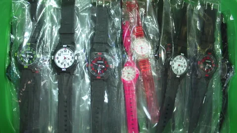 Plastic watches in plastic bag inside green plastic tray 02 Stock Footage 254762030