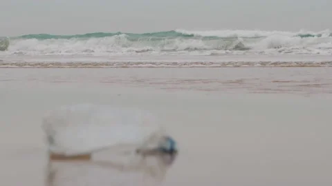 Plastic water bottle on the beach - ocean plastics Stock Footage 147841537