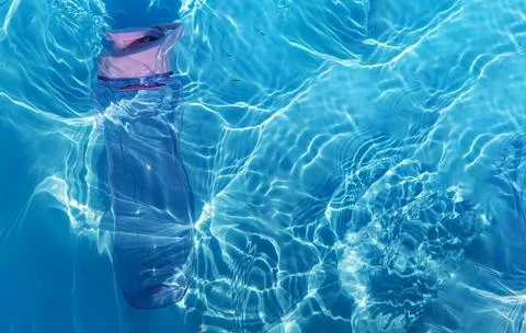A plastic water bottle, lying on the surface of the water. Drops falling on a Stock Photos