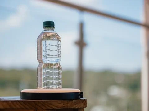 Plastic water bottle on table with blur background and natural light Stock Photos