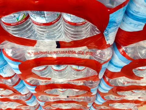 Plastic water bottles in cases with caps for sale supermarket Stock Photos