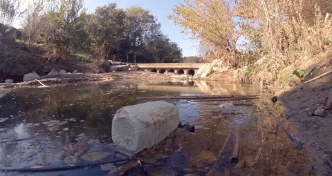Plastic Water Container Floating in Polluted River Environmental Pollution Stock Footage 119911172