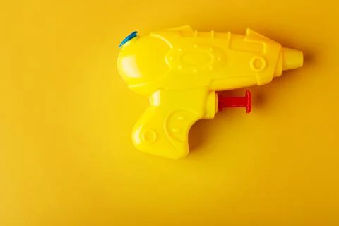 Plastic water gun on yellow background. Toy Squirt pistol. Stock Photos