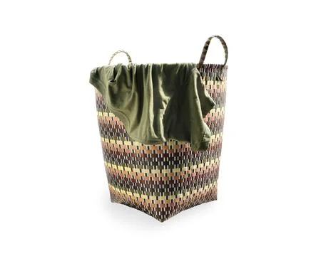 Plastic weaved laundry basket with green T-shirt isolated on white background Stock Photos