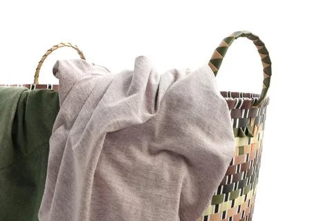Plastic weaved laundry basket with T-shirt isolated on white background  Stock Photos