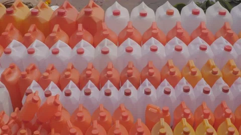 Plastic white and orange cans to selling in the market to bring Gangajal from Stock Footage 221889383