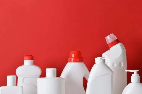 Plastic white bottles on a red background. Layout of bottles with household c Stock Photos
