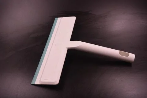 Plastic white tool, an object with a green elastic band for windows. Stock Photos