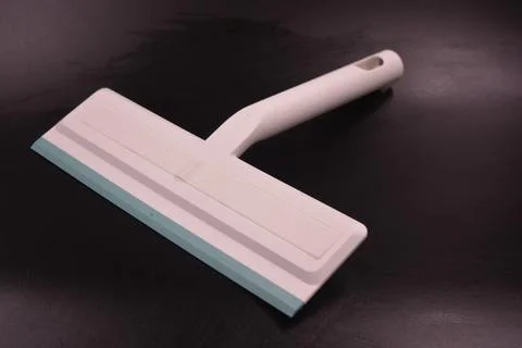 Plastic white tool, an object with a green elastic band for windows. Stock Photos