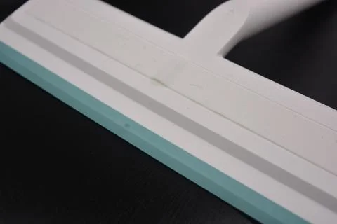 Plastic white tool, an object with a green elastic band for windows. Stock Photos