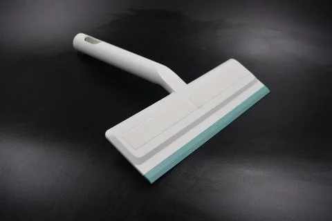 Plastic white tool, an object with a green elastic band for windows. Stock Photos