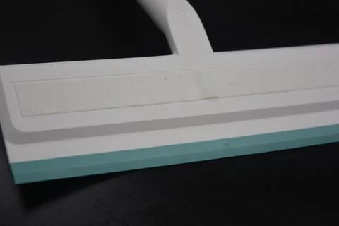 Plastic white tool, an object with a green elastic band for windows. Stock Photos