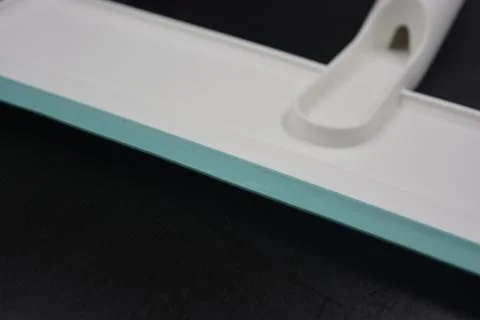 Plastic white tool, an object with a green elastic band for windows. Stock Photos