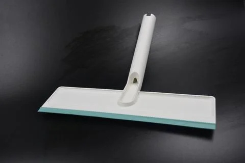 Plastic white tool, an object with a green elastic band for windows. Stock Photos