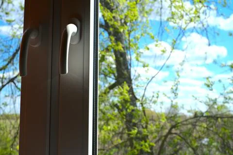 Plastic white windows. And behind them you can see green grass and trees. Stock Photos