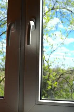 Plastic white windows. And behind them you can see green grass and trees. Foto stock
