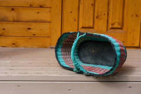 A plastic wicker basket is lying on the floor. Foto stock