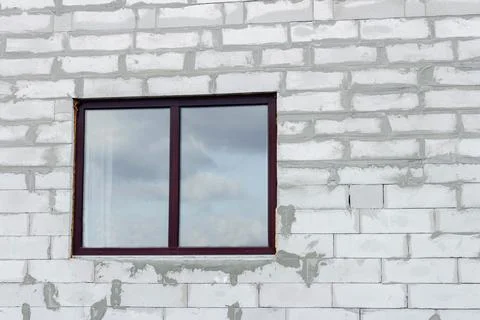 Plastic window on the background of a wall made of foam blocks Stock Photos
