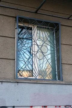 A plastic window in the building on the ground floor with a flat lattice. Stock Photos