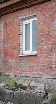 Plastic window in uneven red brick wall, background Stock Photos
