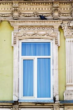 A plastic window in the wall of an old building with stucco molding Stock Photos