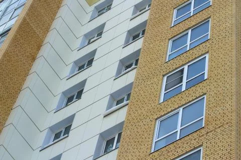Plastic windows in a modern tiled brick high-rise house. Stock Photos