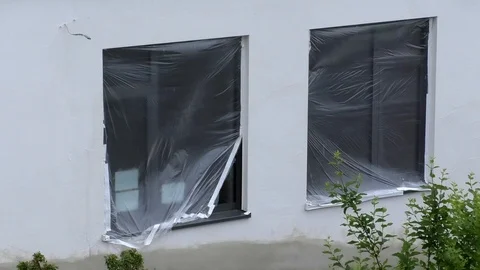 Plastic wrap in front of two windows of a newly constructed building Stock Footage 89912993