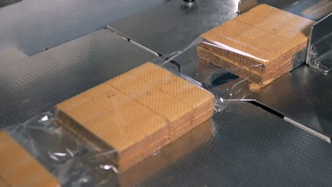 Plastic wrap is getting filled with ready waffles Video stock 87402964