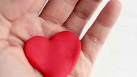 Plasticine clay red color heart shape in kid woman mother son hands palm Stock-Footage 224660853