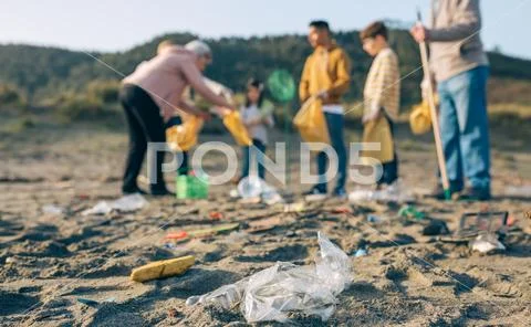 Plastics in the beach with group of volunteers Stock Photos