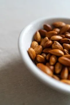 Plate with almonds on a light surface Stock Photos