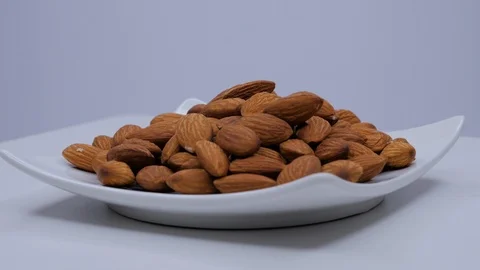 Plate with almonds rotating on a white background Stock Footage 105145624