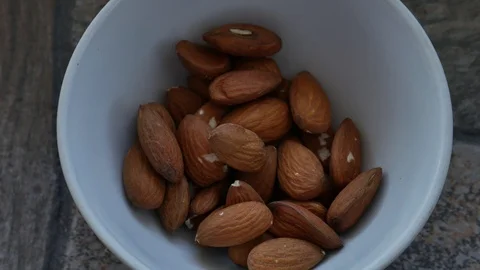 Plate With Almonds Stands on a Stone Surface. Appetizing Almonds Close up Stock Footage 118702519